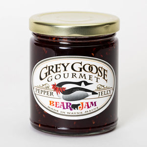 BEAR Jam pepper jelly comes in a clear 9 oz glass jar and is a dark red color with visible raspberry seeds