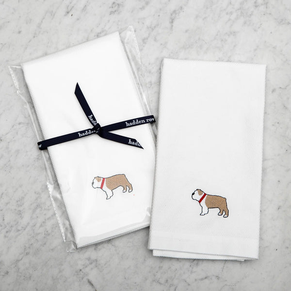 two white tea towels with an embroidered french bulldog with a red collar on a marble background