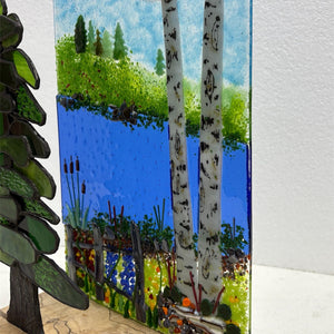 Colorful stained glass art pieces created during Down East Adventures stained glass workshop, showcasing vibrant glass and intricate designs.