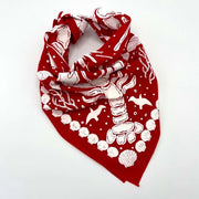 Red nautical bandana by A Wee Maine Artist, featuring maritime-themed design, tied around fabric with nautical motifs.