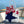Red nautical bandana by A Wee Maine Artist featuring maritime-inspired design, made of soft fabric for versatile wear.