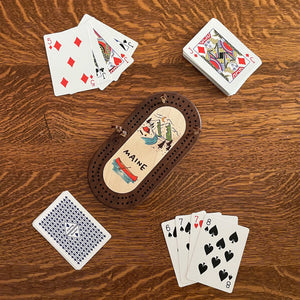 Cast & Carve mini oval cribbage board with pegs and scoring tracks, perfect for travel or casual game nights.