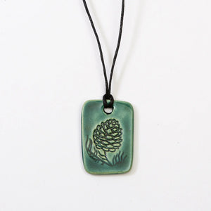 Teal pinecone charm necklace by Jess Teesdale Pottery, featuring a detailed resin pendant on a delicate chain.
