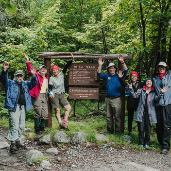 Scenic view of Mount Katahdin during a hiking trip, with lush greenery and a clear sky, captured by Down East Adventures.