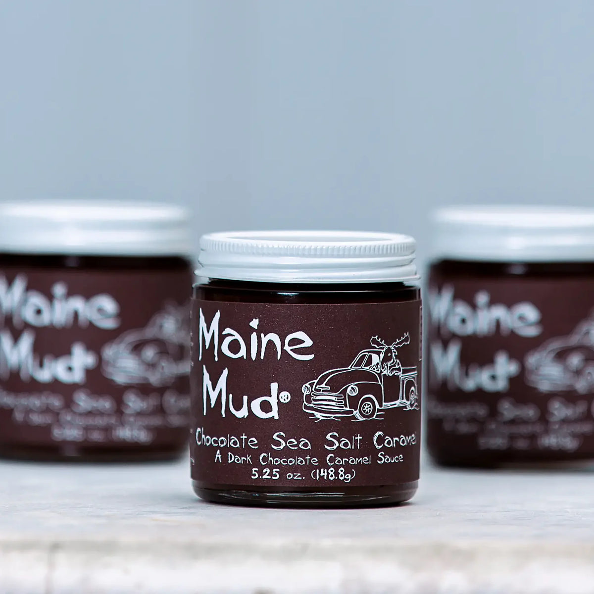 Wilbur's Maine Mud dark chocolate caramel sauce in a jar, rich and smooth with a glossy finish, perfect for desserts.