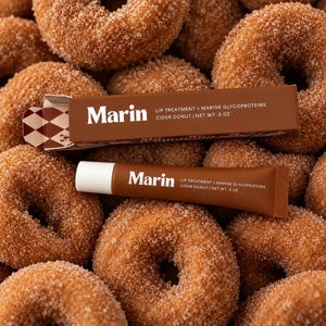 Marin Skincare Cider Donut Lip Treatment tube with a soft pink cap and product branding, displayed on a neutral background.