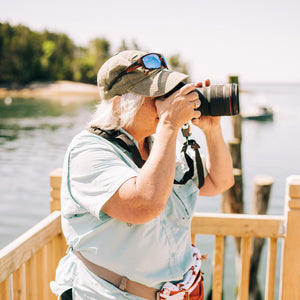 Beginner photography workshop hosted by Down East Adventures, featuring participants practicing camera skills outdoors.