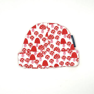 Baby hat with red mushroom pattern on a white background