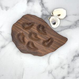 Hand-carved walnut oyster platter with six well sections by Oyster River Joinery, showcasing detailed craftsmanship and natural wood grain.