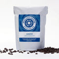 Organic dark roast coffee beans from Rock City Coffee, showing a close-up of glossy, dark brown roasted beans.