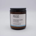 Downeast Dew scented candle by Wayward Chickadee with a clear glass jar and a lit wick, showcasing a cozy, aromatic candle.