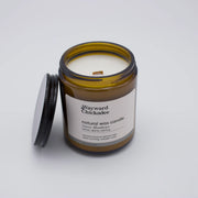 Swiss Meadows scented candle by Wayward Chickadee, showing the candle without a lid, with a white wax and simple design.