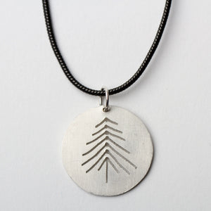 Sterling silver disc pendant necklace featuring a pine tree design, crafted by LSF Design + Fabrication.