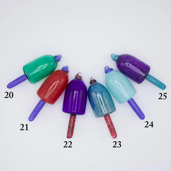 Group of colorful nautical glass buoy ornaments by Casco Bay Glassworks, featuring vibrant glass floats on a white background.