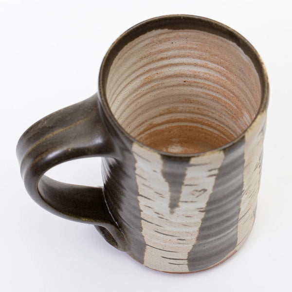 The inside of the mug has a light wash of white glaze over the natural color of the pottery