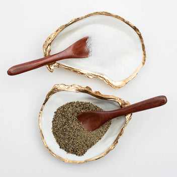 Gilded oyster-shaped salt and pepper cellars by Latitude 43 Designs, featuring elegant gold accents and intricate oyster detailing.