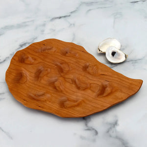 Hand-carved cherry oyster platters by Oyster River Joinery showcasing smooth, natural wood finish and elegant presentation surface.