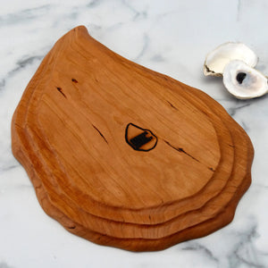 Hand-carved cherry oyster platter by Oyster River Joinery, showcasing a smooth, elegant serving board with natural wood grain.