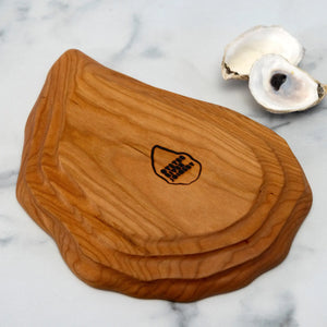 Small hand-carved cherry oyster platter by Oyster River Joinery, featuring natural wood grain and elegant, organic shape.