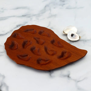 Hand-carved oyster platter by Oyster River Joinery, made from rich mahogany wood, showcasing a smooth, elegant serving surface.