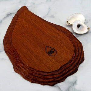 Hand-carved oyster platter from Oyster River Joinery, made of rich mahogany, showcasing detailed craftsmanship for serving seafood.