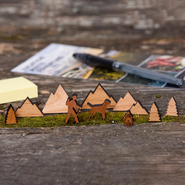 163 Design Company small wooden pieces include hiker, dog, camp light, mountains, and pine trees