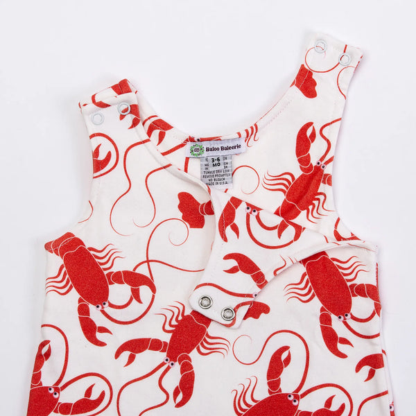 Baloo Baleerie closeup of child's white romper with red lobsters repeated design and 2 snap closure on both shoulders showing one side unsnapped