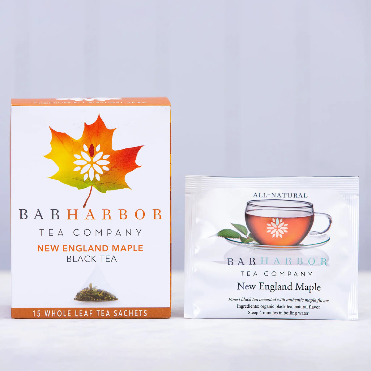 Boxed tea bags featuring Bar Harbor Tea Company's New England Maple flavor with a colorful map design on the packaging.