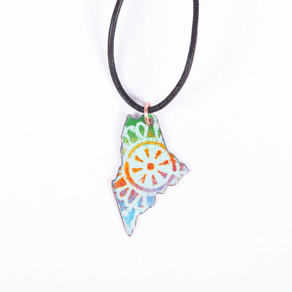 Blueberry Bay Jewelry state of Maine copper enameled necklace with rainbow mandala design hangs from a black leather cord