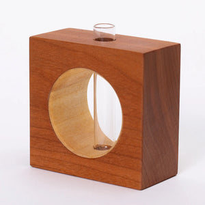 Cherry-colored ceramic bud vase by S.E. Hall Furniture with a sleek, minimalist design and narrow opening.