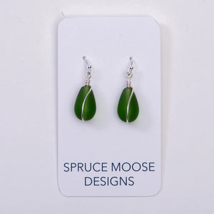 Cultured sea glass teardrop earrings by Spruce Moose Designs featuring green emerald-colored glass and silver hooks.
