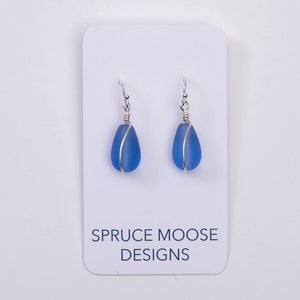 Cultured sea glass teardrop earrings by Spruce Moose Designs featuring periwinkle blue glass drops on silver hooks.
