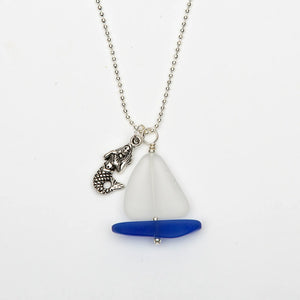 Sea glass necklace by Valerie Paul featuring a sailboat and mermaid charm on a delicate chain.