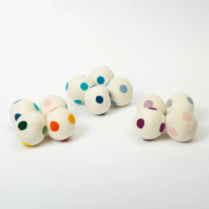 Bee Dandy white dryer balls in a grouping of rainbow, blue, and purple polka dotted sets
