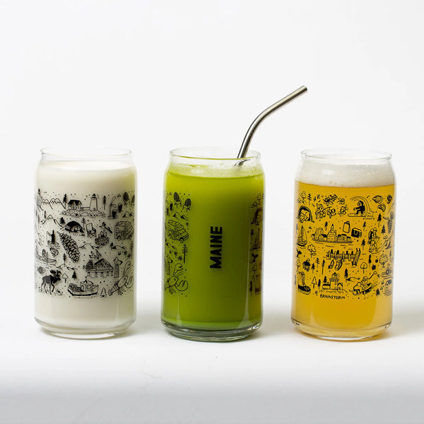 Brainstorm 3 Maine beer can glasses showing different sides and filled with milk, filled with matcha, filled with beer and includes the Maine doodle designs in black