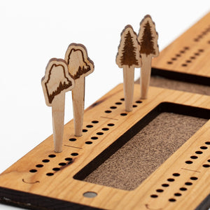 Cast & Carve travel cribbage board with colorful pegs and compact design, perfect for portable game play.
