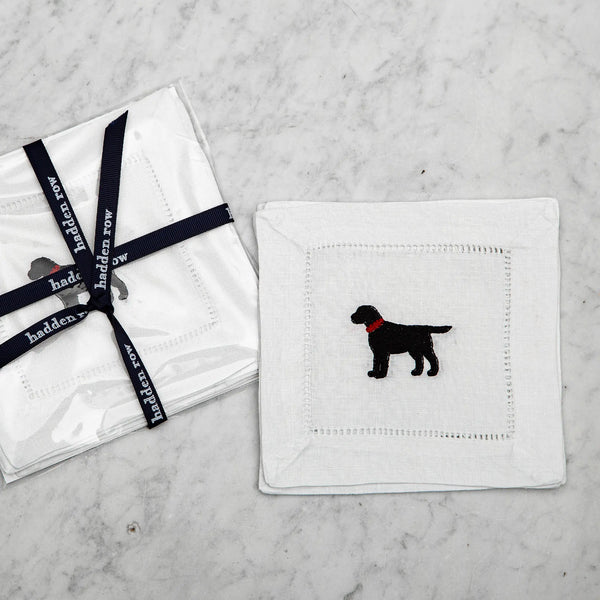 Linen cocktail napkin with an embroidered black lab with a red collar on a marble background