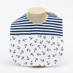 Navy baby bib with anchor pattern from Two Little Beans & Co., made of soft, absorbent fabric for mealtime messes.
